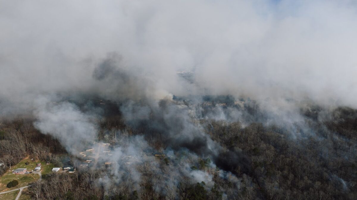 Aerial view capturing a forest fire with dense smoke in Georgia.