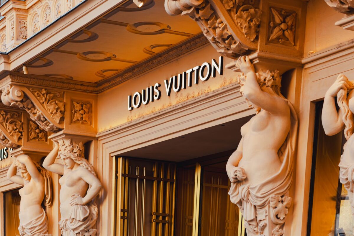 Grand facade of Louis Vuitton store featuring ornate sculptures in Vienna's shopping district.